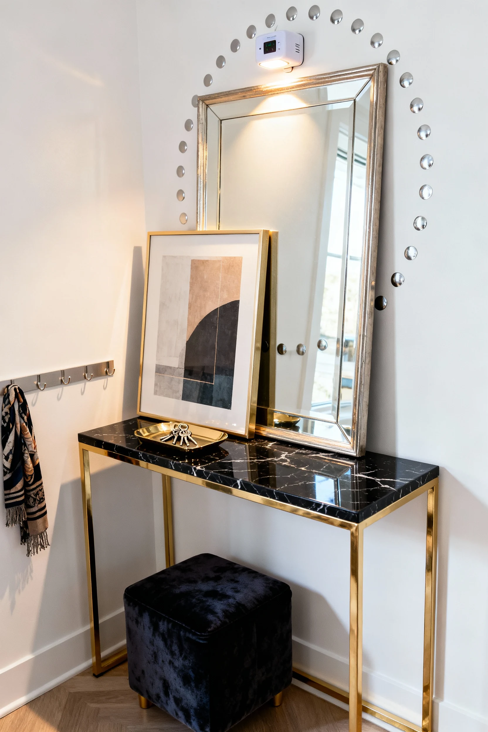 Photorealistic medium, straight-on shot of a modern glam entryway vignette: narrow console table with brass legs and a b