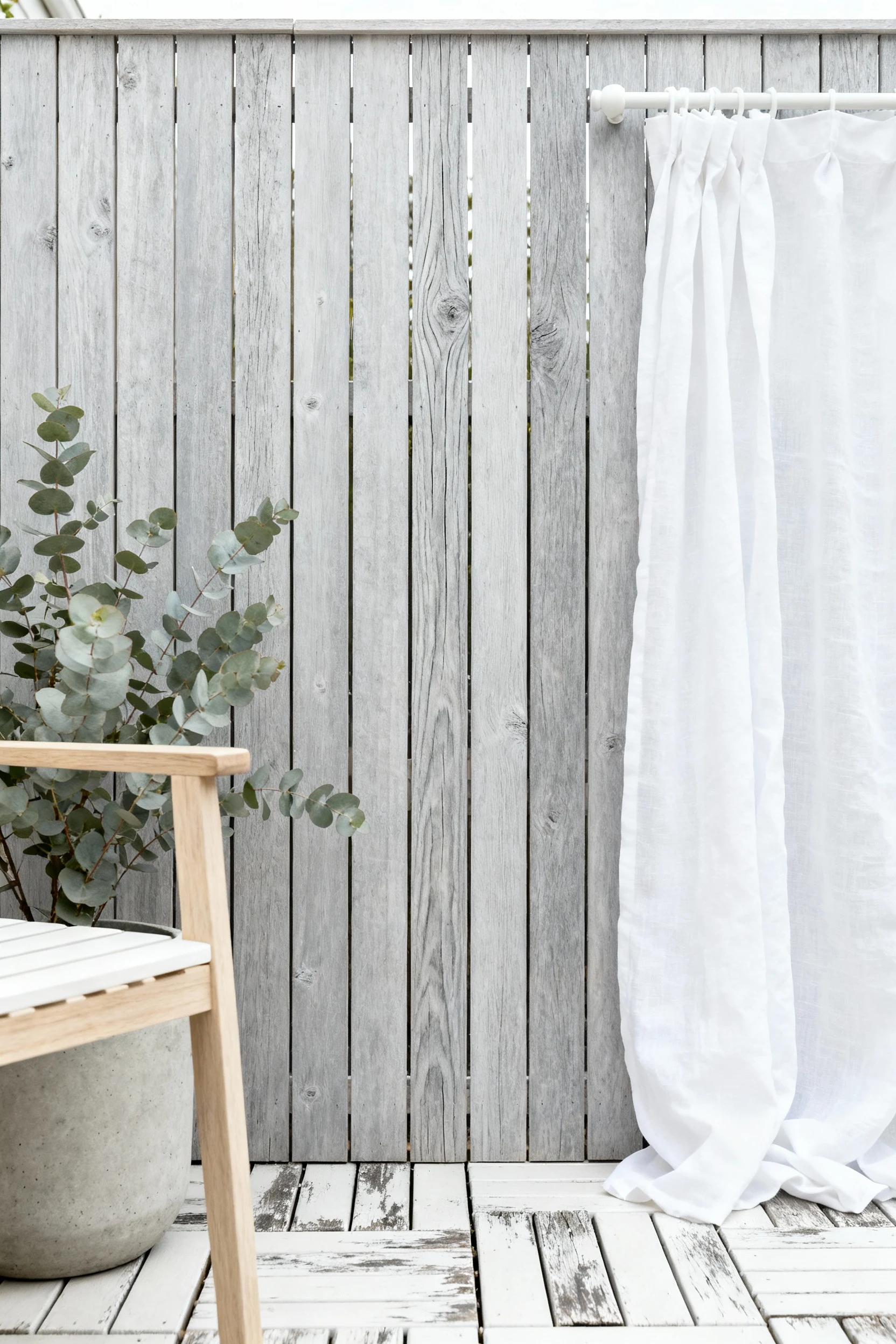 Photorealistic close-up detail shot, straight-on: a DIY vertical cedar slat screen paired with breezy white linen curtai