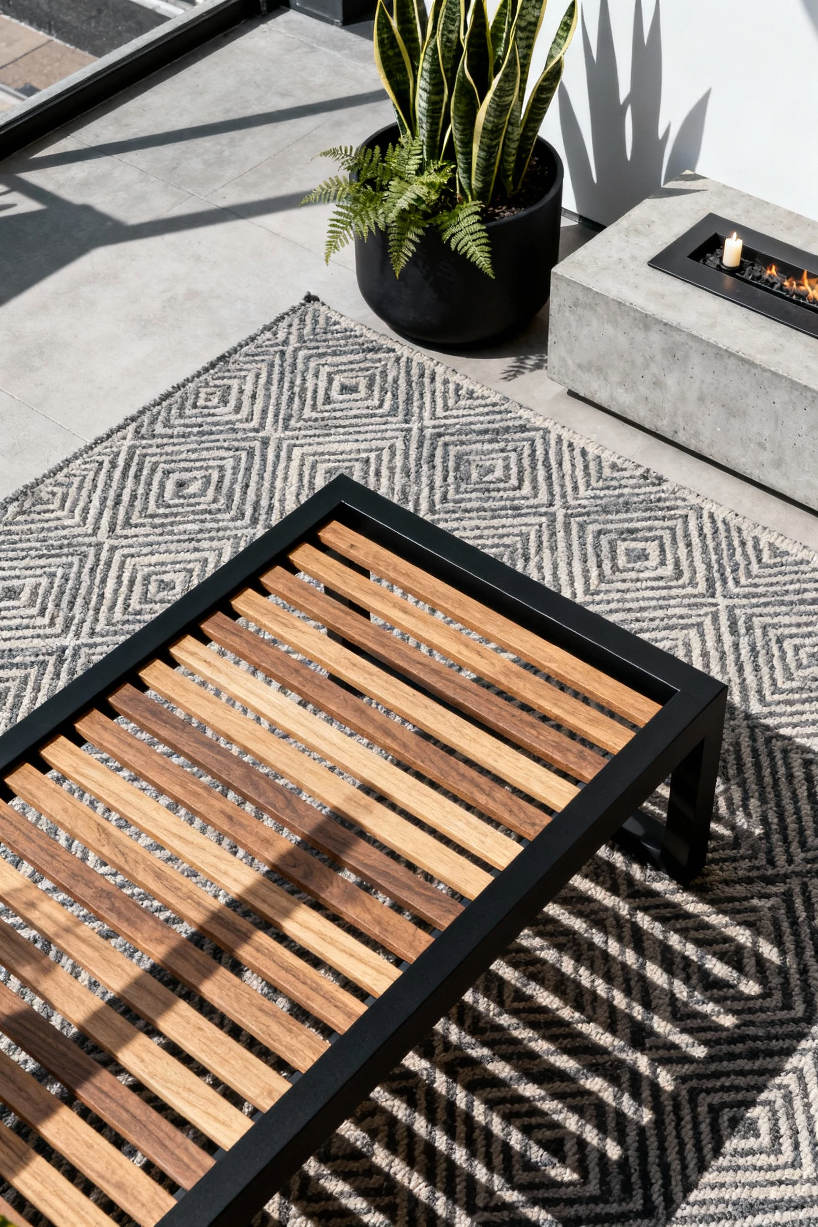 Photorealistic high-angle overhead detail of a modern slatted screen lounge: sunlit cedar slats in a matte black frame c