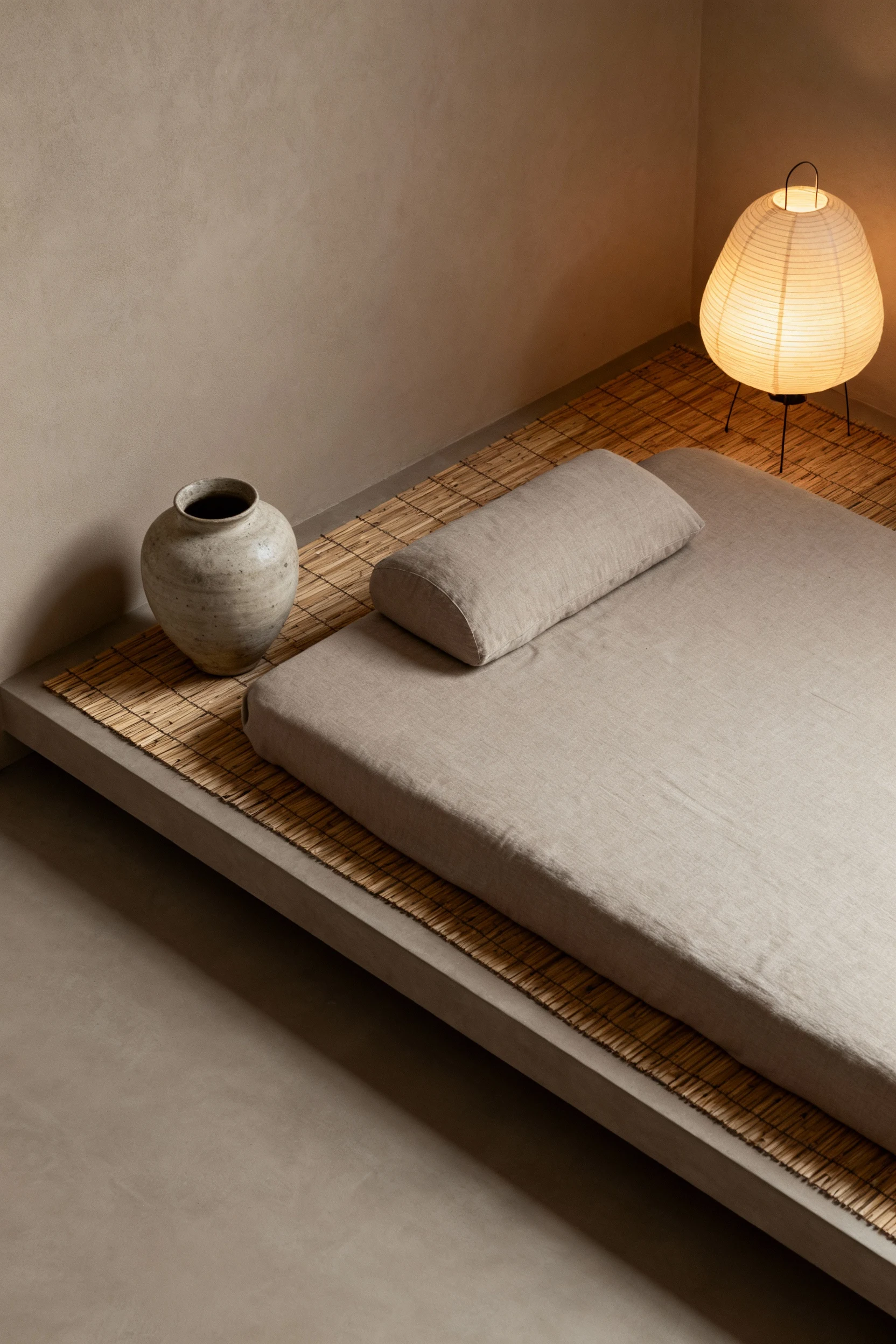 4. Overhead top-down shot of a Japandi calm corner: low platform futon on a bamboo mat, stoneware vase arranged beside i