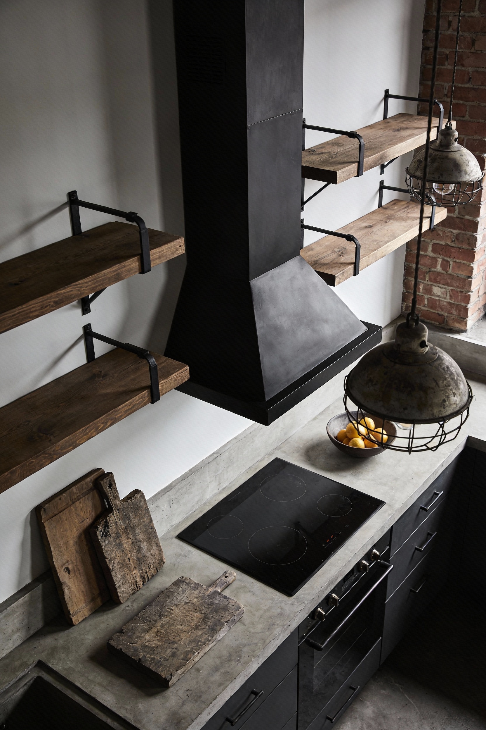 Overhead detail shot, photorealistic bold industrial loft kitchen styling on a concrete countertop beneath a tall blacke